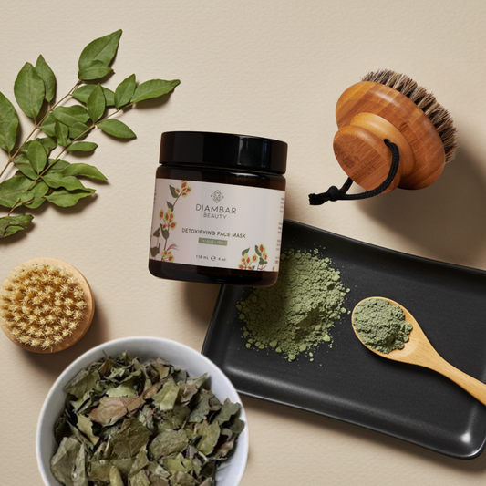 a luxurious detoxifying face mask in an amber jar, tipped slightly on its side with finely milled powder spilling onto a sleek black ceramic tray. A wooden spoon rests nearby, showcasing a precise scoop of the mask’s earthy texture